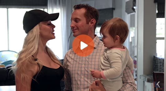2 adult and a baby with play button